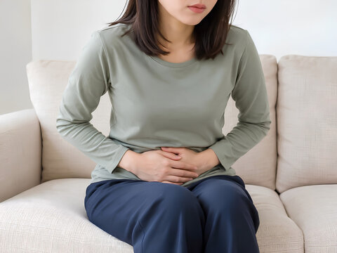 お腹をおさえる女性