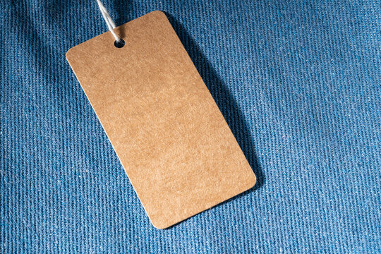 Blank kraft paper label on blue denim textile background