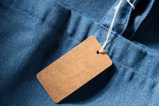 Blank kraft paper label on blue denim textile
