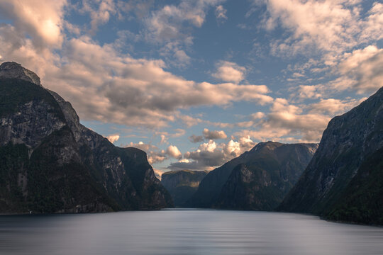 Dramatic Norwegian fjord beneath clouds at sunset