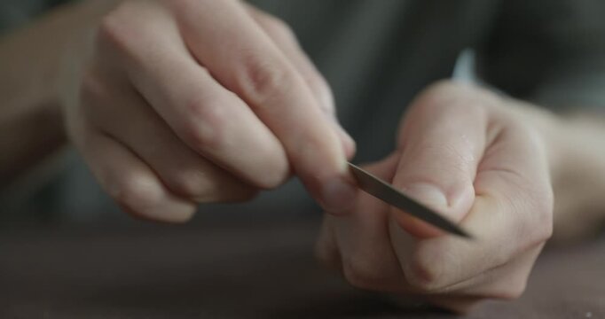 Close-up male hands do filing nails manicure. 4K 10-bit