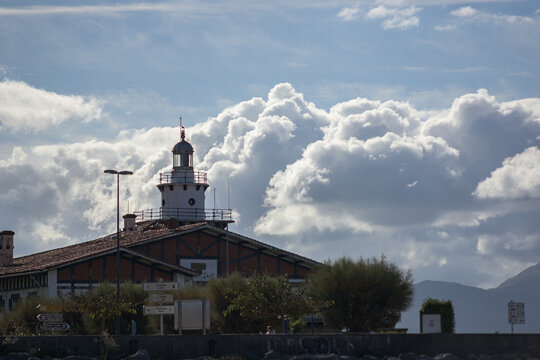 Historic sea rescue station building and lighthouse under dramatic cloudy sky in Arriluze promenade, Getxo, Bizkaia, coastal architecture