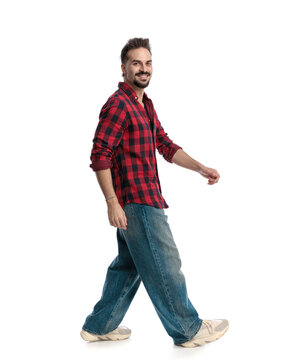 Side view of cheerful man walking smiling