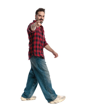 Side view of casual man walking and pointing forward