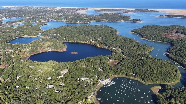 A bird's eye view of Orleans on outer Cape Cod, MA, shows kettle ponds and Pleasant Bay which is connected to the Atlantic Ocean. This scenic area is a popular east coast vacation destination.