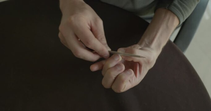 Close-up male hands do filing nails manicure. 4K 10-bit