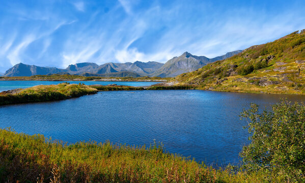 Scenic coastal landscape at Lyngvaer with blue water and rugged mountains in the Lofoten Islands, Norway