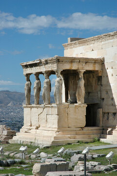 The iconic Caryatid porch featuring sculpted stone statues acting as supporting columns at the ancient Erechtheion temple on the Acropolis in Athens Greece.