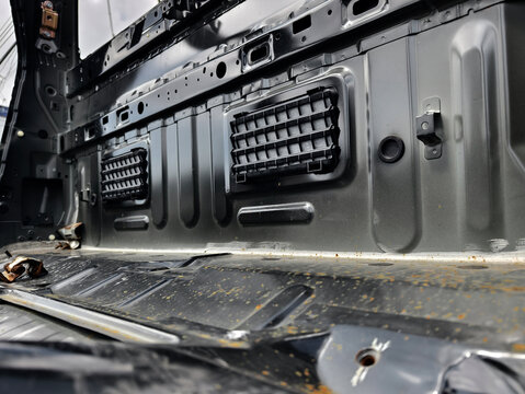 Charred metal car shell with exposed frame rails and burnt interior floor pans