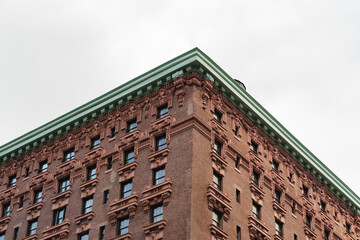 Ornate brick facade with decorative windows and a green cornice © Look Around Studio