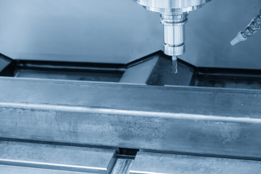 CNC milling machine cutting a metal steel pipe with a flat nose end mill tool in a light blue tone