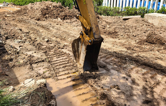 Excavator dredging mud and soil on construction site