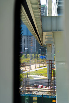 View of a developing urban area and construction though the window of a moving suspended monorail train in Wuhan, China