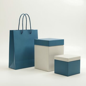 A blue paper shopping bag and two gift boxes with lids isolated on a white background