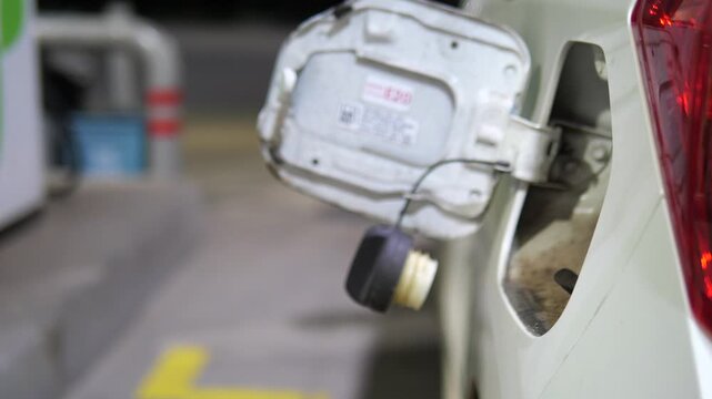 Close up of refueling car with fuel nozzle at gas station