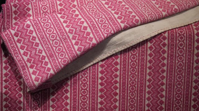 Close up of traditional red and white woven fabric with intricate geometric patterns