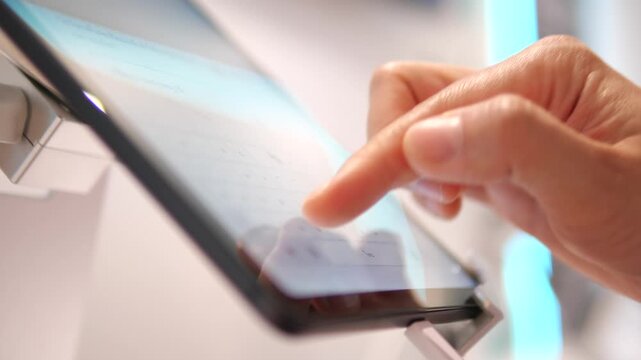 Close up of hand using and typing on digital tablet screen
