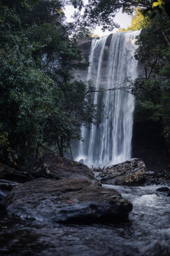 Tall Huai Luang Waterfall Above a Rocky Forest River