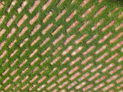 Red brick pattern with green grass tiled floor. Brick, boxed Pattern, Concrete, Crisscross, Formal Garden.