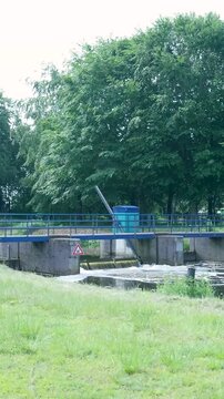 Water flowing over a small weir dam in a green landscape