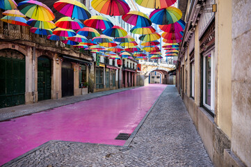 Fototapeta premium Colorful Umbrellas Above Pink Street in Lisbon Portugal