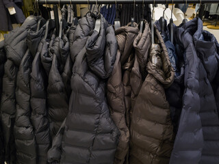 Padded winter puffer jackets hanging on retail store rack © Ольга Кібукевич