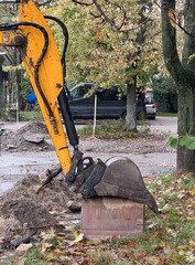 Yellow excavator arm and bucket at urban excavation site in autumn © Nataliia