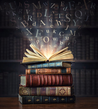 Old book with flying letters and magic light on the background of the bookshelf in the library. Ancient books as a symbol of knowledge, history, memory and information.