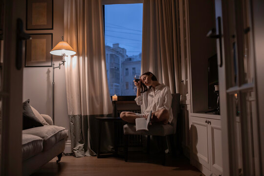Tired woman with a book and a glass of wine