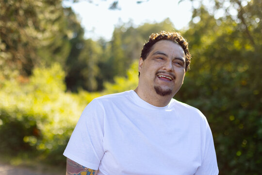 Smiling man outdoors in white t-shirt enjoying sunny nature