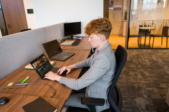 Man Using Laptop At The Desk in Modern Office