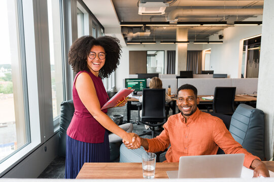 Cheerful Coworkers Shake Hands in an Office