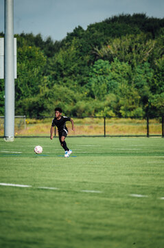 Young Athlete Runs on Soccer Field During Practice Session