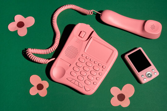 Vintage Pink Telephone, Digital Camera and Paper Flower on Green Table