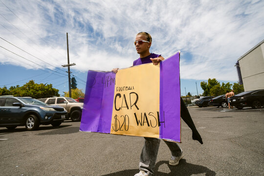 Teen Holding Sign for Car Wash Fundraising