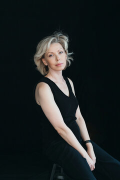 Elegant Woman in Timeless Pose Against a Dark Backdrop