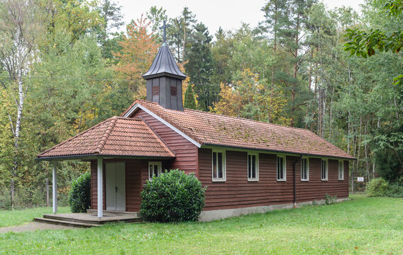 The Secret in the Woods. Historic Wooden Church Maria Rosenkranzkoenigin. Built in 1953 by refugees at the Muna Langlau camp. In the background, the fence to the forbidden, hazardous zone.
