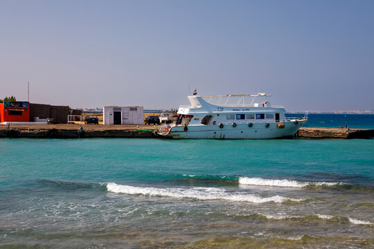 Scenic view of a white cruise boat docked at a pier by the turquoise sea