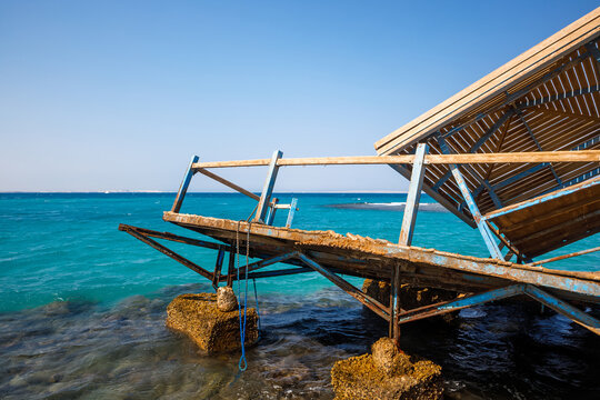 Scenic view of broken and collapsed wooden pier by turquoise sea
