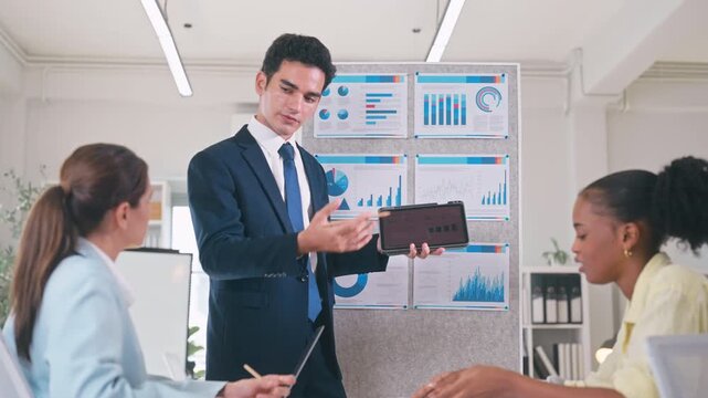 Businessman team meeting pointing at a presentation board, explaining data and strategy