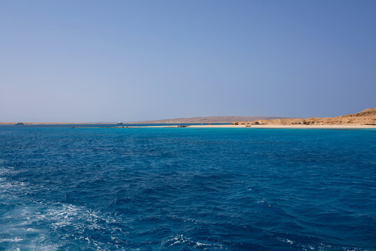 Scenic coral reef in turquoise ocean water near desert coastline