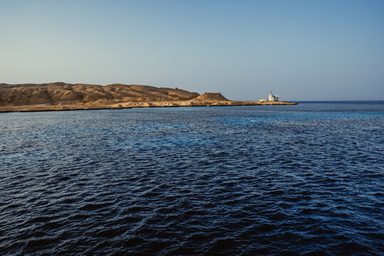 Scenic desert coastline with white house by the deep blue sea