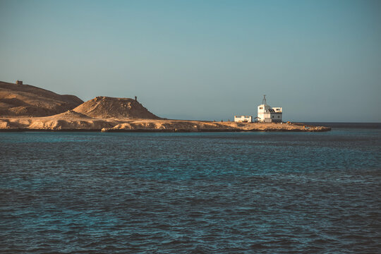 Scenic desert coastline with white house by the deep blue sea