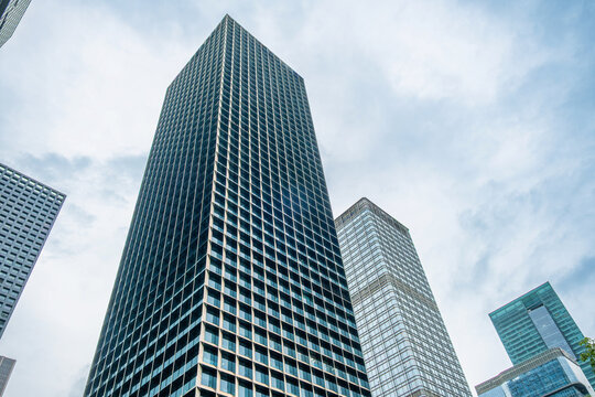 Modern high-rise buildings in Shenzhen city, China, with geometric window grids and glass facades against the sky. Skyscraper architecture, business district, corporate property, urban development