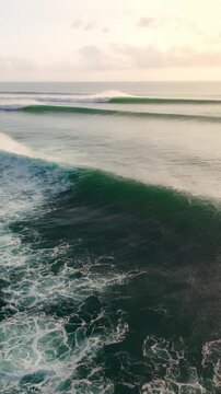 Drone view with breaking ocean waves in ocean in Bali
