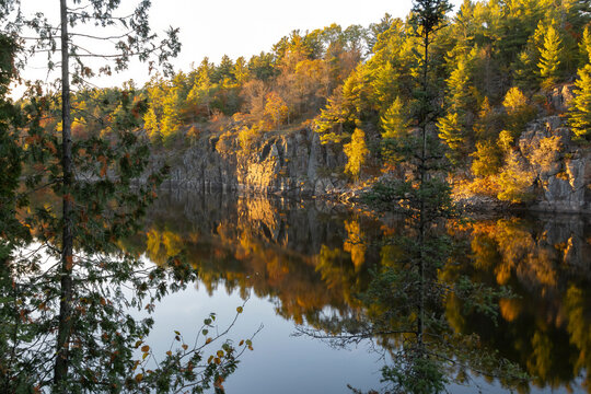 Serene autumn landscape in French River Provincial Park, Ontario, with vibrant foliage reflected in water along Recolett Falls Trail.