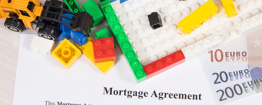 House under construction made of toy blocks, Euro, mortgage agreement form. Renting real estate and building home