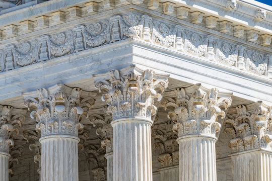 Closeup perspective of Supreme Court columns representing justice system and constitutional government authority ideals