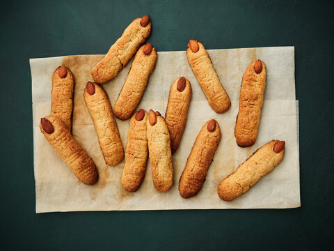 Almond cookies shaped like fingers on parchment paper, Halloween treats concept for festive gatherings