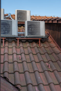 Air conditioning units on a red tiled roof.